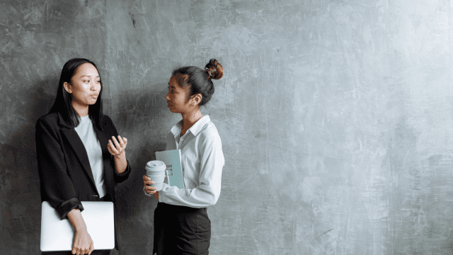 建物の中で会話をするふたりの若い女性